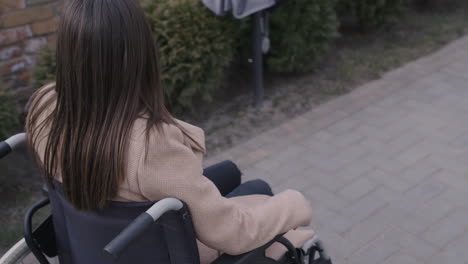 rear view of a woman wheelchair turning around her head and waving at camera