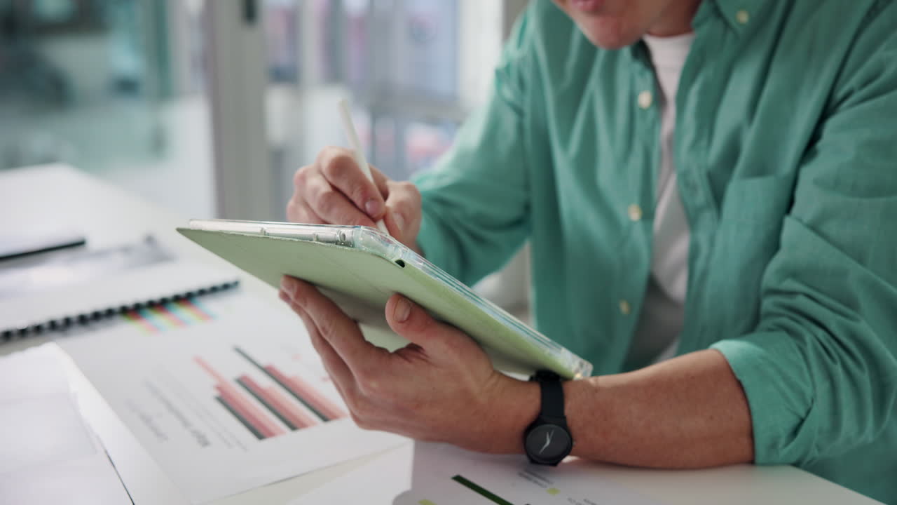Man working on a tablet with charts and graphs