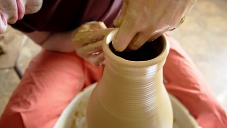 pottery artist shaping clay on wheel