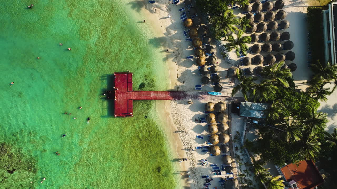 Top down drone shot rising above a pier at a paradise beach in Tulum, Mexico