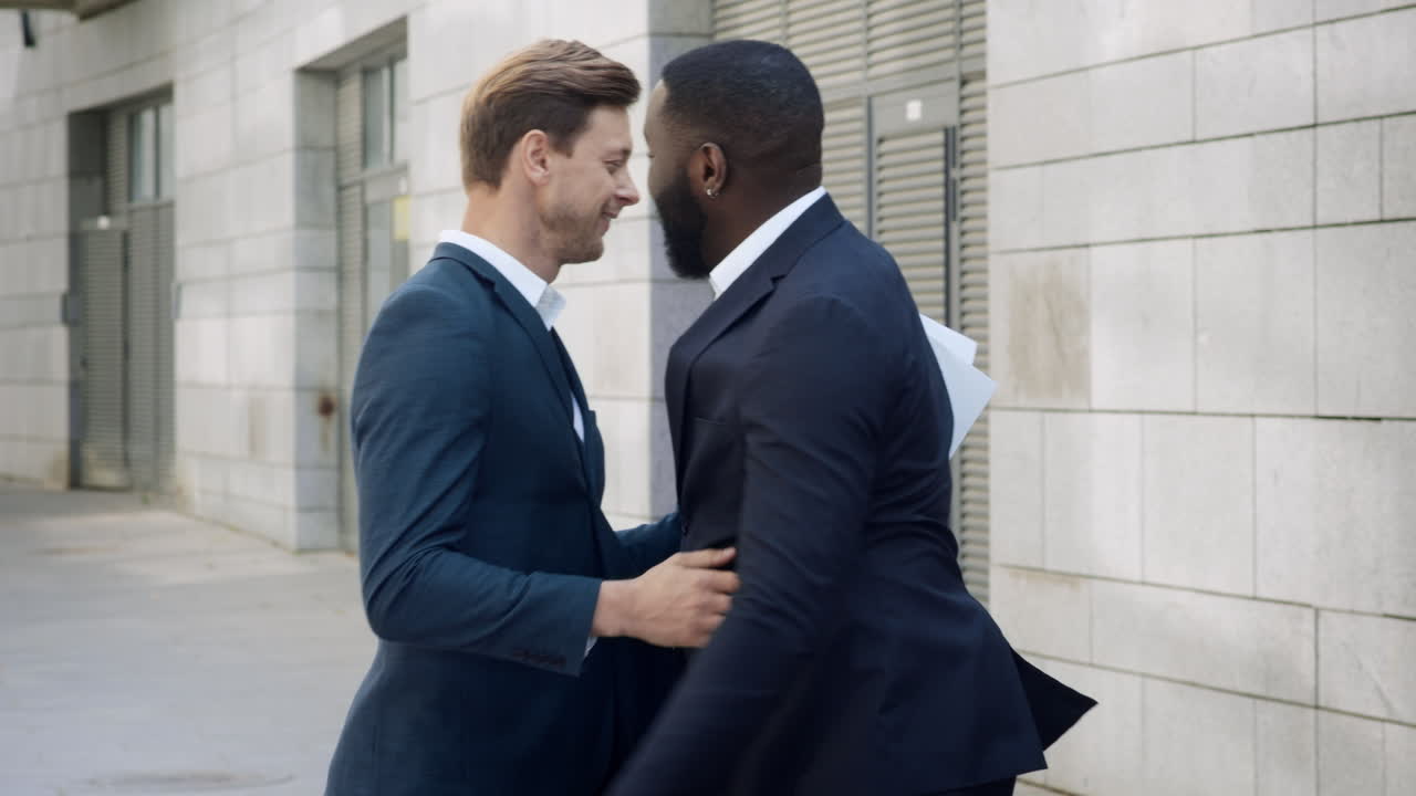 hombres de negocios se reúnen en la calle de la ciudad. los socios se saludan al aire libre