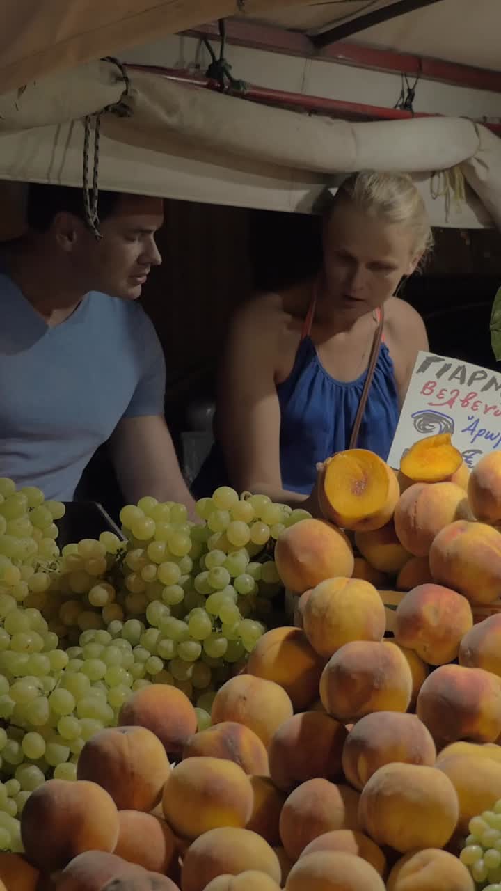 Koppel winkelt voor vers fruit op een buitenmarkt