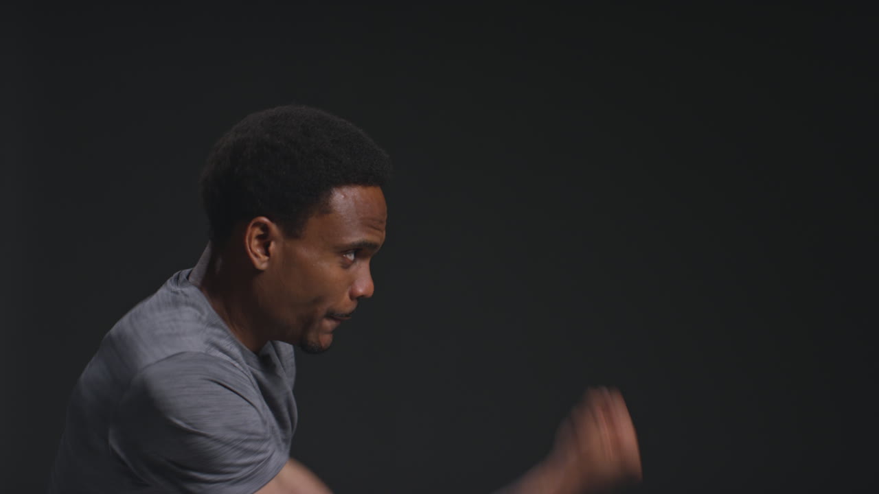 Close Up Profile Shot Of Male Boxer Training In Gym Sparring Preparing For Fight Against Black Studio Background 2