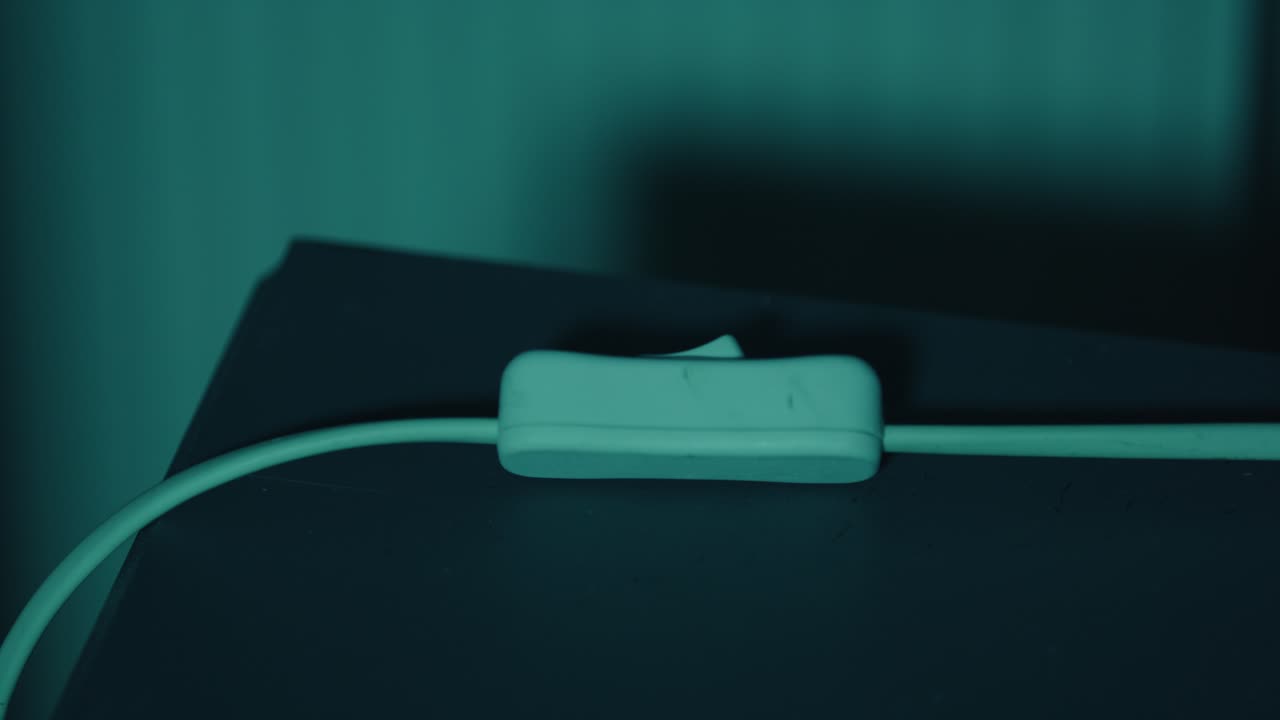 un primer plano extremo de un interruptor de lámpara simple que se enciende tarde en la noche