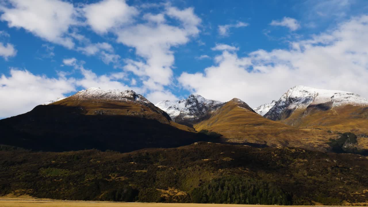 épicas montañas cubiertas de amarillo con pico nevado en el parque nacional de fiordland durante la temporada de otoño