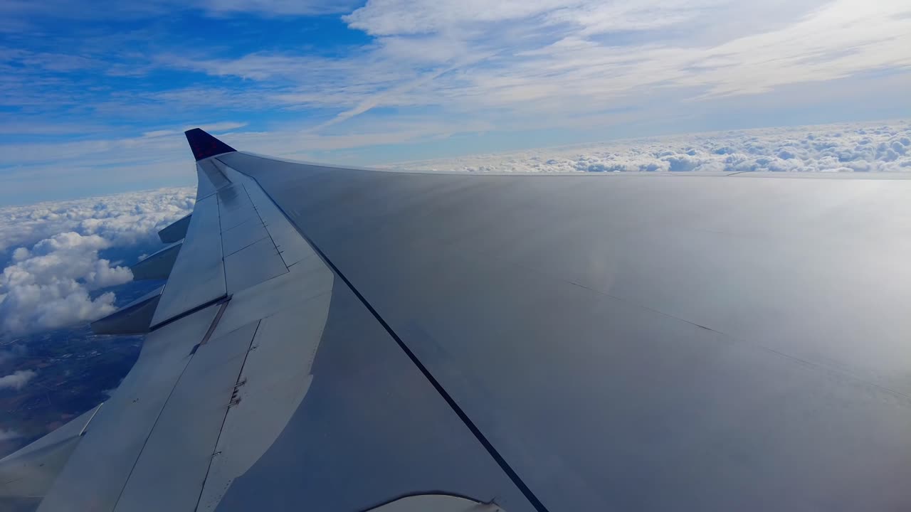 아름다운 눈  구름과 푸른 하늘을 가진 비행기 날개는 비행기 창문을 통해 은 날을 볼 수 있습니다.