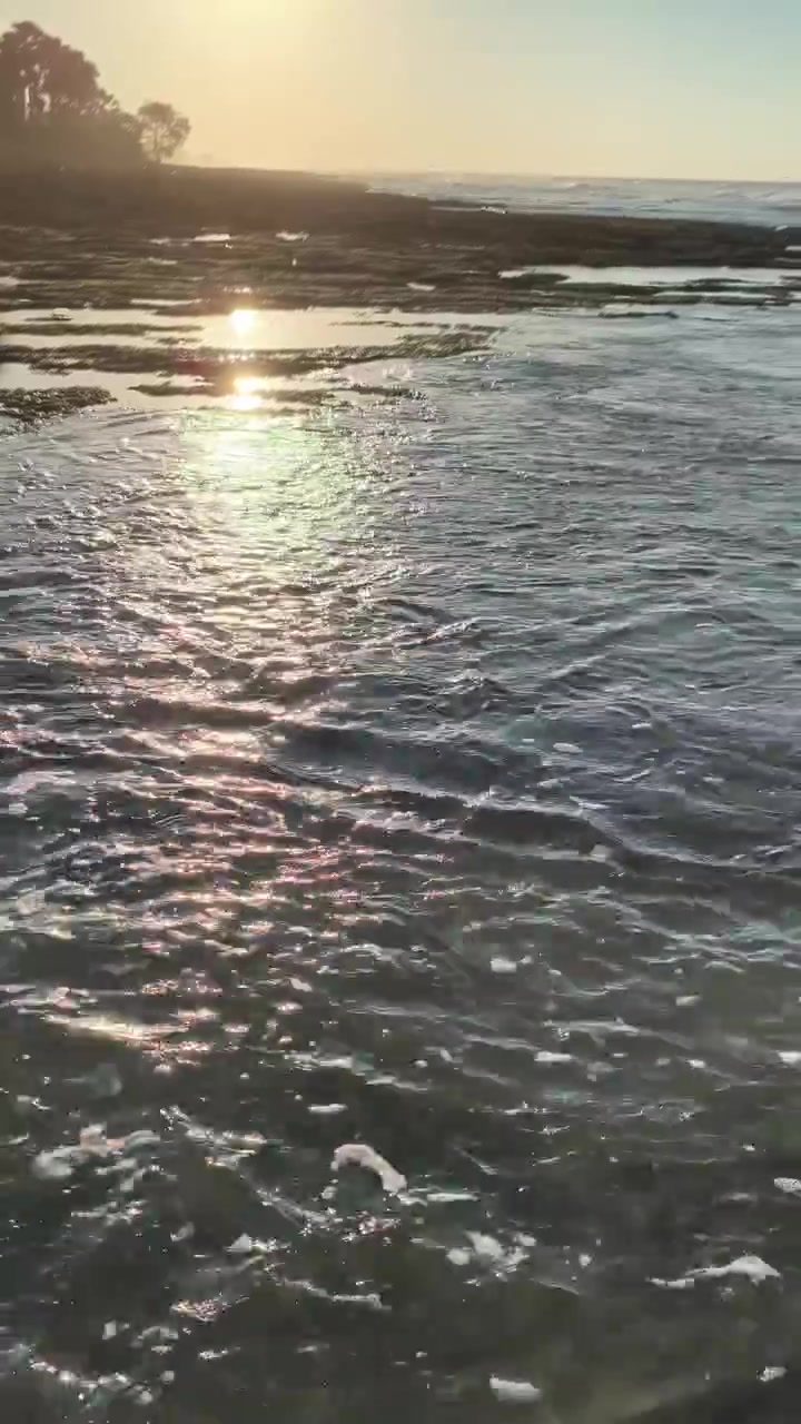 Gentle Ocean Waves Washing Over Rocky Shore at Sunset