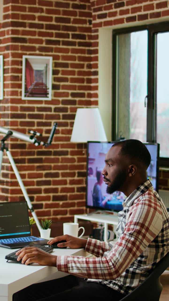 Vertical Video African american software engineer works on laptop typing code for a project