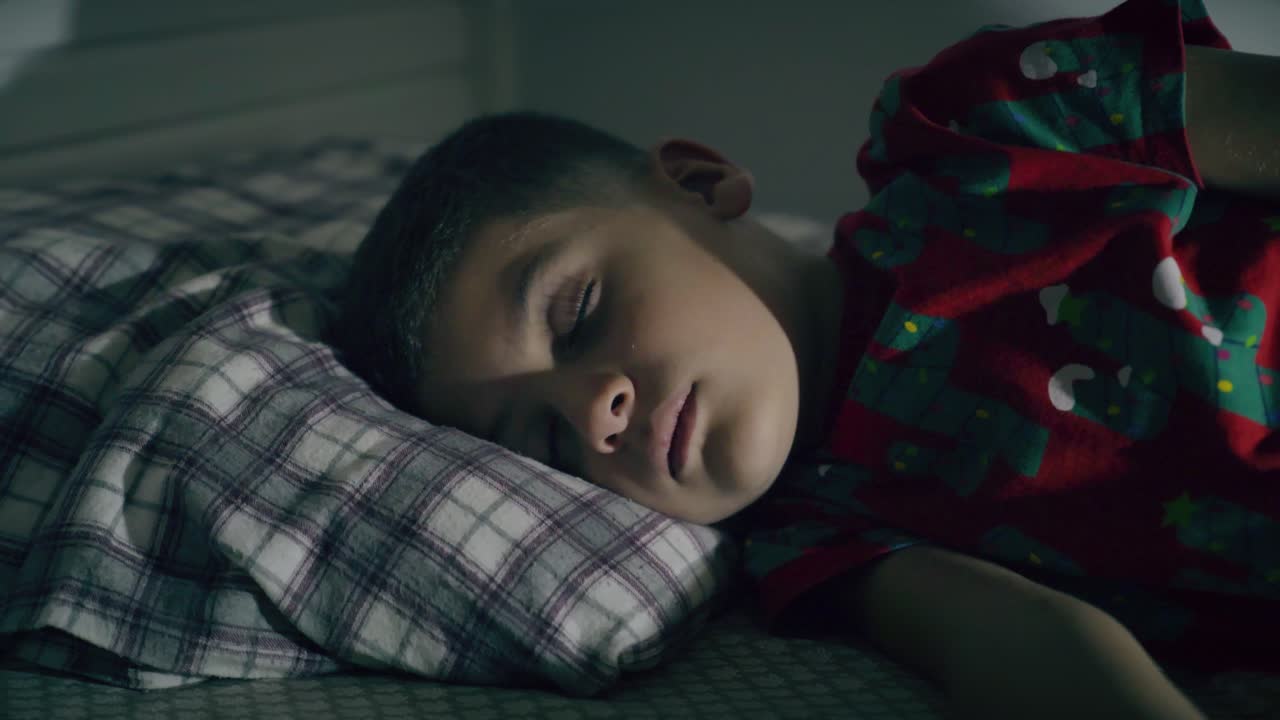 침대 위 에 있는 방 에서 밤 에 잠을 자는 아이