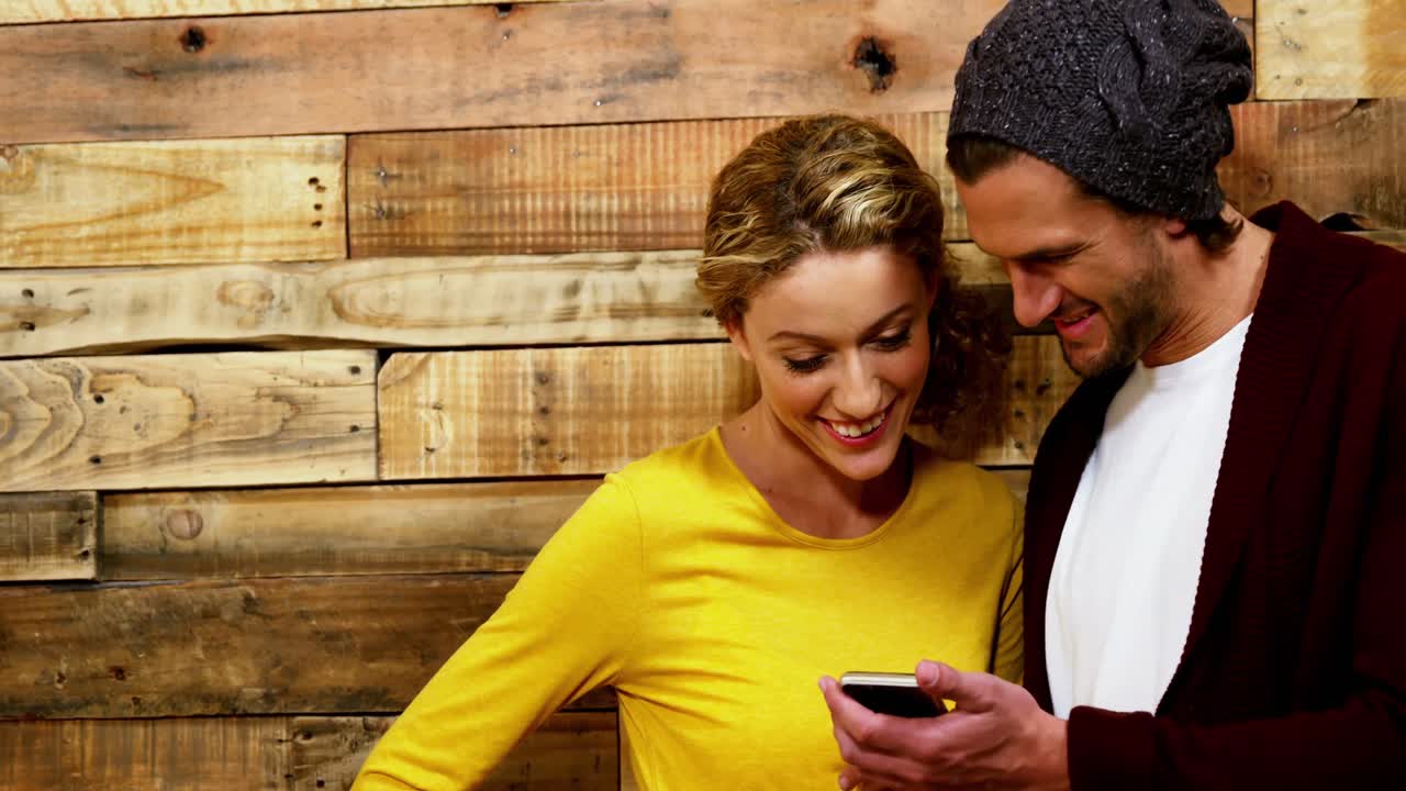 Couple using mobile phone in caf&Atilde;&copy;