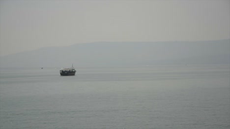 A-reproduction-of-a-2,000-year-old-fishing-boat,-slowly-crossing-the-historic-Sea-of-Galilee-in-Israel