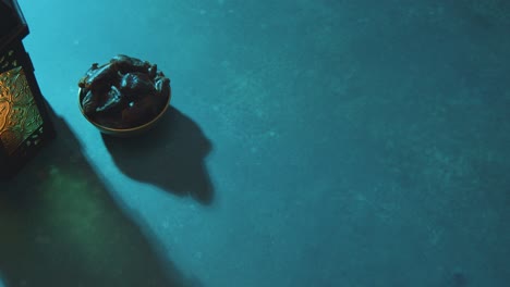 high angle tracking shot of some dates and lantern on table