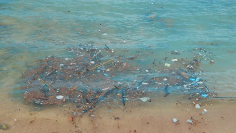contaminación plástica flotando en el mar caribe en playa tropical, cámara lenta