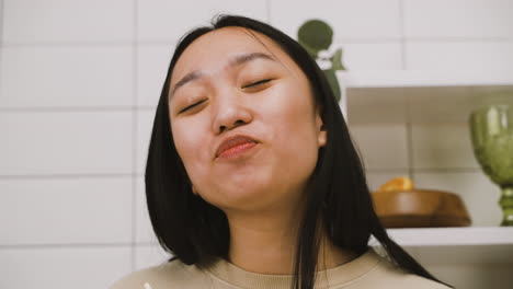 close up view of happy japanese girl eating takeaway ramen in the kitchen