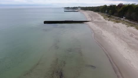 Aerial-Shot-of-Ystad-Saltsjöbad-on-a-Cloudy-Day-in-South-Sweden-Skåne-With-Piers-and-Trees-By-The-Beach-Near-Östersjön