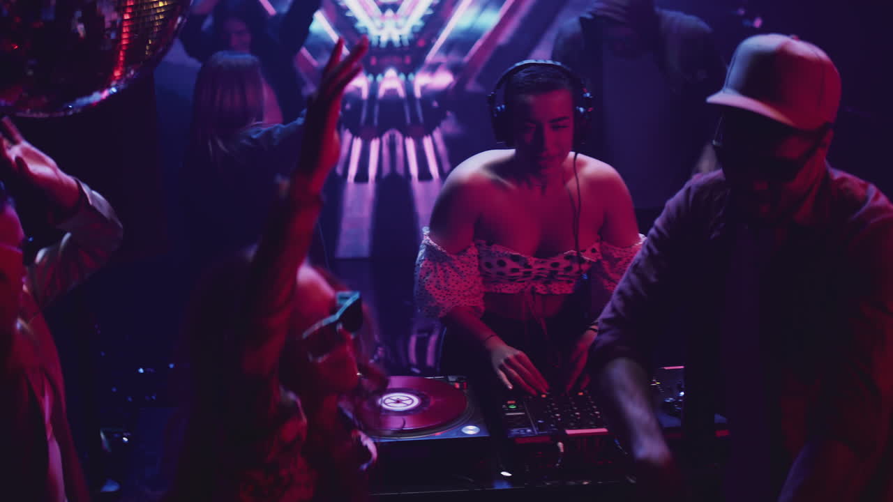 fiesta en un club nocturno con djs y multitud bailando