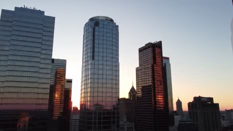 the vibrant sunset paints the skyline in shades of orange and pink, while sleek skyscrapers reflect the colors of dusk in a bustling urban environment.