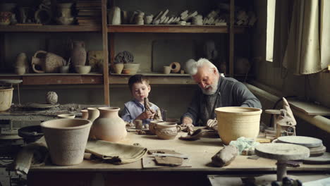 grandfather and grandson working together in pottery workshop