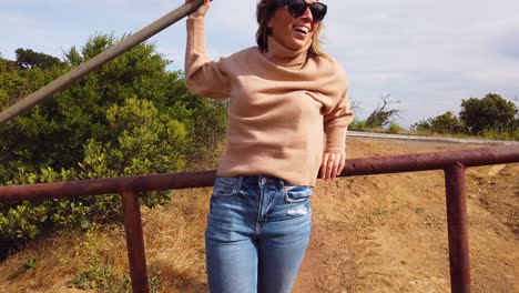 Slow-Motion-Girl-Cowgirl-Leans-On-A-Gate-Or-Fence-At-A-Farm-Smiling