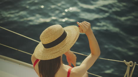 woman wearing a straw hat on a yacht