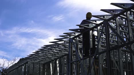 man building structure of a steel frame house