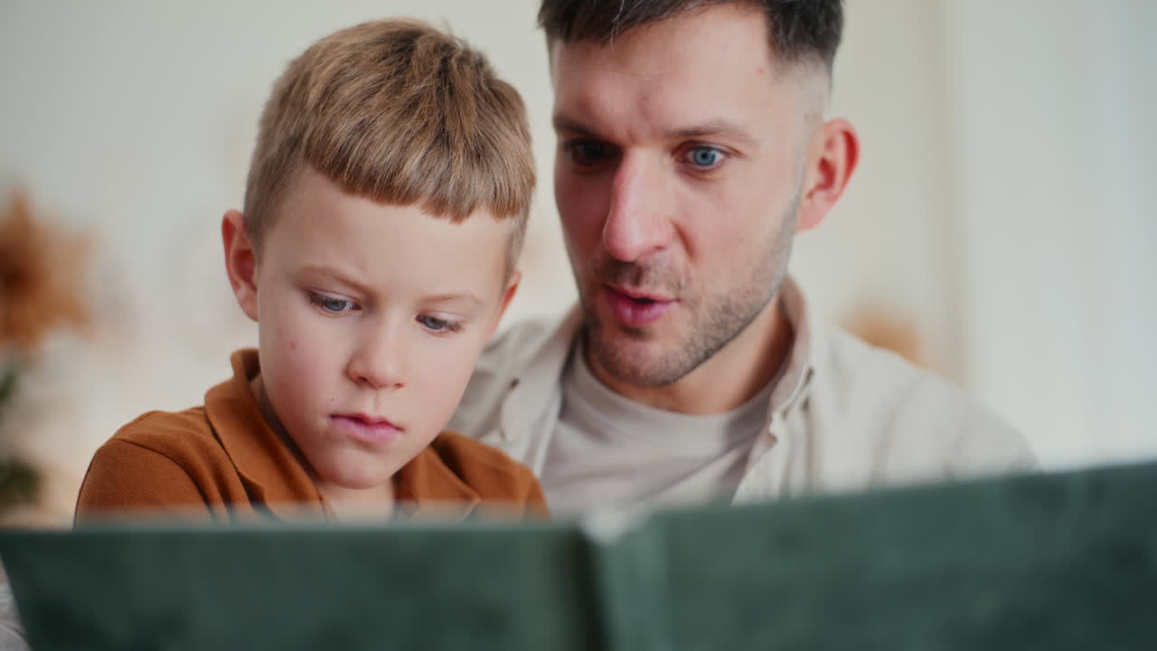 un niño y su padre miran fotos de sus antepasados en un álbum familiar