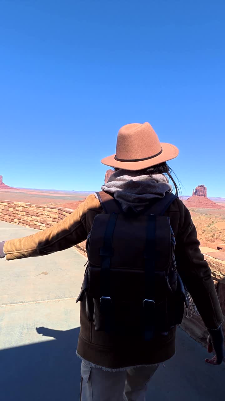 Donna che si avventura per ammirare il vasto paesaggio desertico della Monument Valley