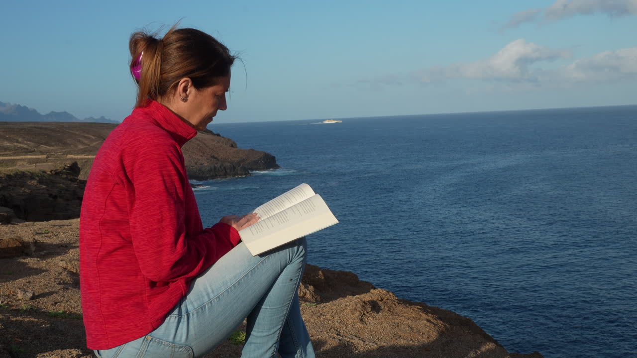 Woman enjoys reading a book in a beautiful seascape