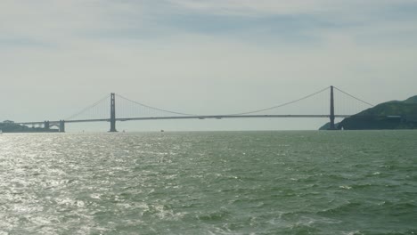 golden gate bridge view from the water in san francisco bay on a cloudy day