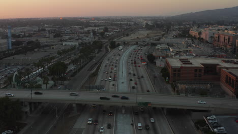 Antenne:-über-Viel-Befahrener-Autobahn-Bei-Sonnenuntergang-Mit-Palmen-In-Burbank,-Los-Angeles,-Kalifornien,-Sonnenuntergang