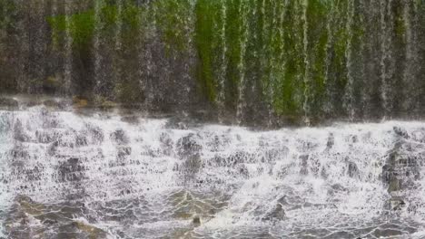 beautiful scene of water falling over rocks in the water falls at a rain forest