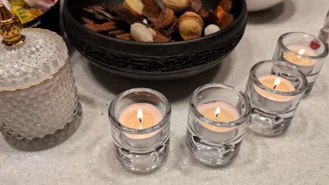 close up shot of glass with flickering candles burning in a glass on a table