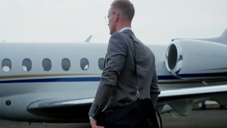 businessman walking towards private jet 4k