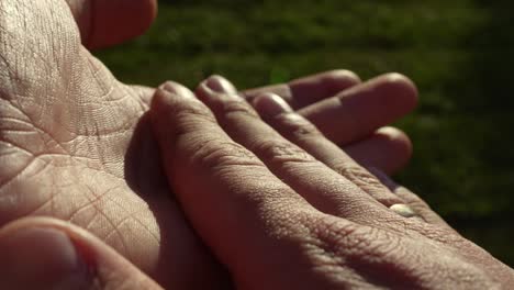 Lit-hands-of-person-clapping-slowly-and-shows-thumbs-up,-macro-close-up