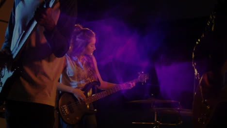 bandmates performing on dim stage, displaying animated music notes and neon equalizer bars
