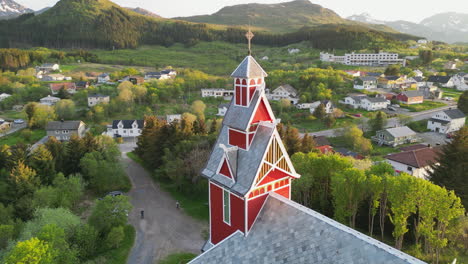 Puesta-De-Sol-Sobre-La-Iglesia-Roja-De-Buksnes,-Noruega-Desde-Arriba