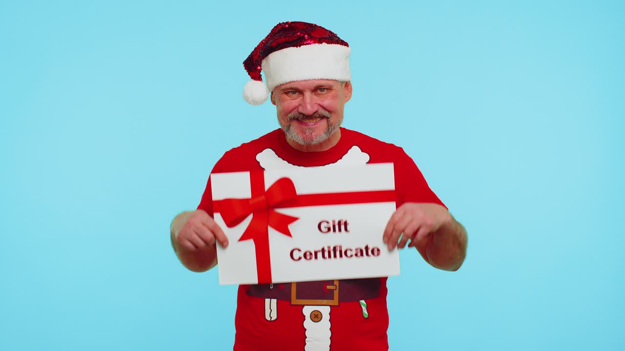 Funny man wears red new year tshirt and hat presenting card gift certificate coupon winner voucher