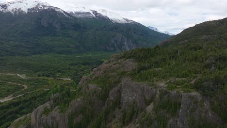 Aerial-Flying-Over-Mountain-To-Reveal-Futaleufu-River-With-Snow-Capped-Mountains-In-Background