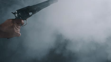 person discharging vintage revolver with visible smoke