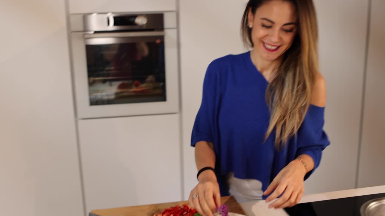 Vlogger sorridente con un cavolfiore che parla davanti allo smartphone a casa