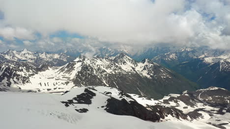 vuelo aéreo a través de nubes montañosas sobre hermosos picos nevados de montañas y glaciares.