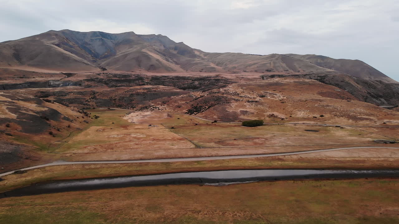 Aerial view of a mountain landscape with a lake and road