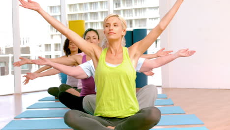 yoga class raising their hands