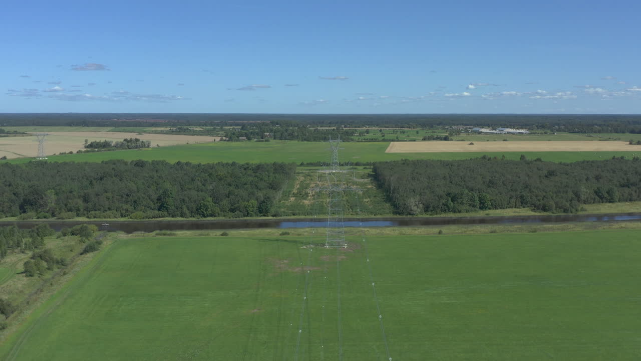 Aerial view above power lines in a panoramic greenfield environment