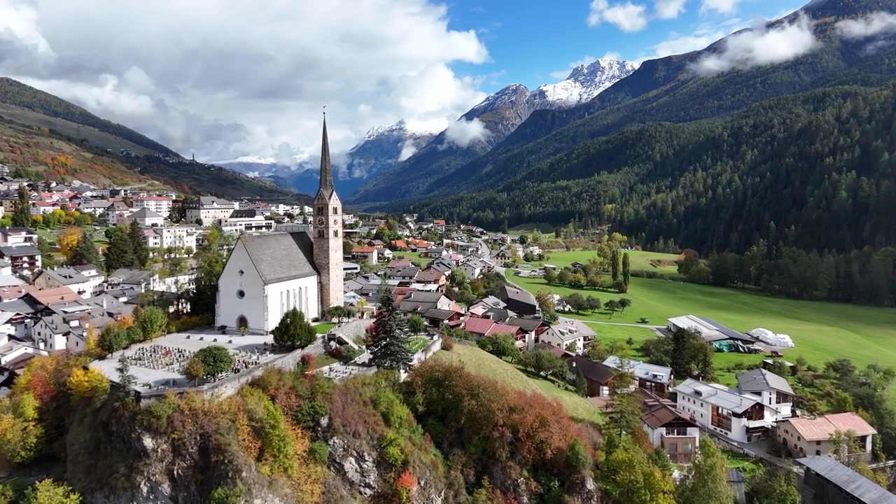 Dorf Scuol, umgeben von Bergen, Wald und einem Fluss in der Schweiz, Luftaufnahme