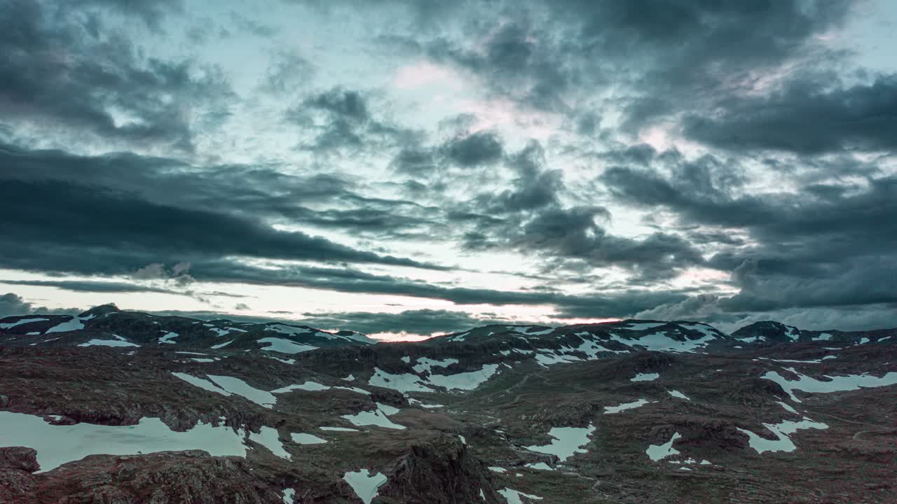 взгляд зрителя на то, как великолепные мрачные облакаформируются и меняют форму на закатном небе над скалистыми горными склонами в норвегии
