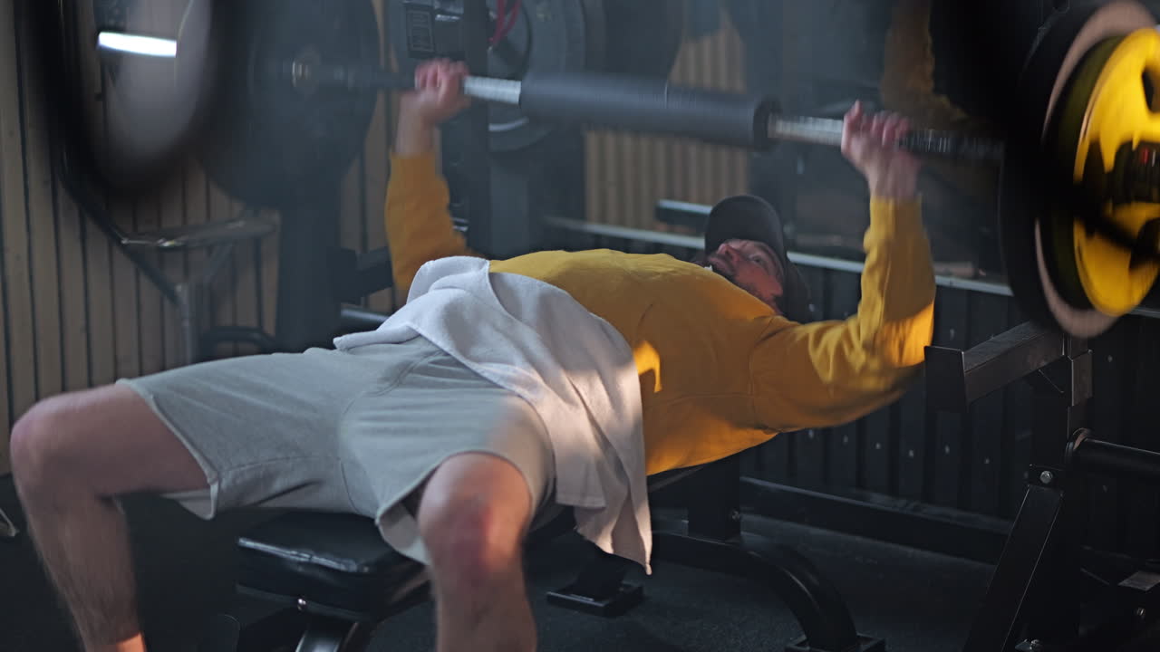 Close up of man doing bench press in home gym