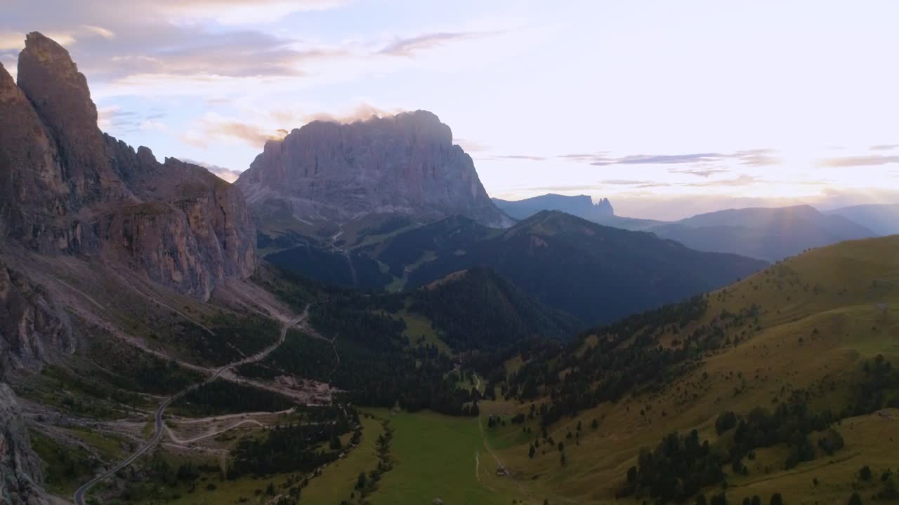 Aerial, reverse, drone shot, of  Sassolungo mountain, on Gardena pass, Dolomiti sunset, on a sunny, summer evening, in Dolomites, Tyrol, Italy