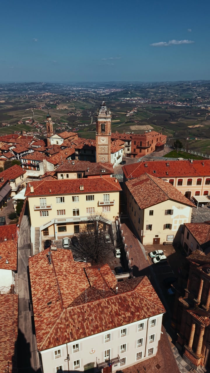 Iconic Piazza Castello viewpoint in La Morra with famous bell tower, Piedmont, vertical drone aerial