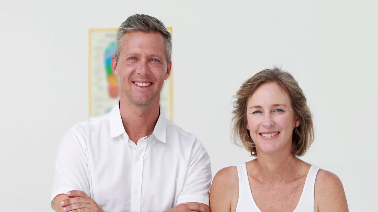 physiotherapeut und patient lächeln in die kamera